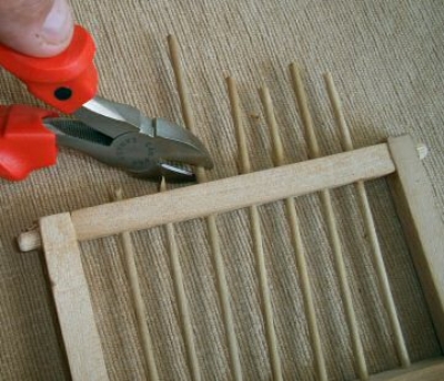 excess 1/8th inch doweling rods are clipped close to top beam, sanded smooth